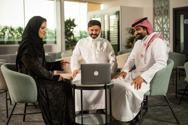 اجتماع عمل في الخارج، العمل الجماعي وروح الفريق، مناقشة الخطط والاستراتيجيات، استخدام اللابتوب في تدوين الملاحظات، الاحترافية والتفاني في الإنجاز، فريق عربي خليجي سعودي يتبادل الافكار والاراء، ضمان فهم واضح وشامل للاعمال