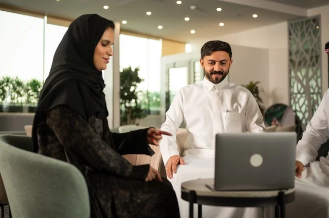 اجتماع عمل في الخارج، العمل الجماعي وروح الفريق، مناقشة الخطط والاستراتيجيات، استخدام اللابتوب في تدوين الملاحظات، الاحترافية والتفاني في الإنجاز، فريق عربي خليجي سعودي يتبادل الافكار والاراء، ضمان فهم واضح وشامل للاعمال