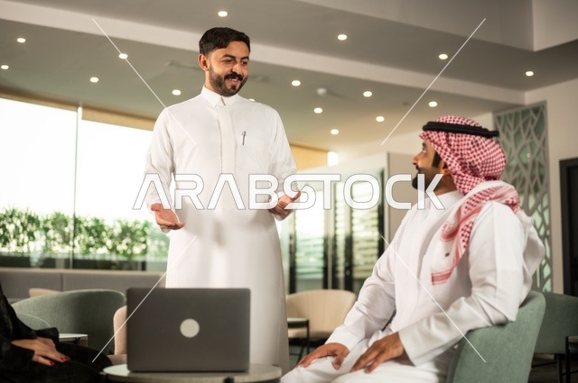 اجتماع عمل في الخارج، العمل الجماعي وروح الفريق، مناقشة الخطط والاستراتيجيات، استخدام اللابتوب في تدوين الملاحظات، الاحترافية والتفاني في الإنجاز، فريق عربي خليجي سعودي يتبادل الافكار والاراء، ضمان فهم واضح وشامل للاعمال