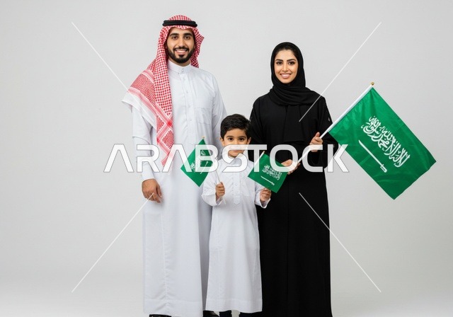 ذكرى العيد الوطني السعودي، اليوم الوطني لتوحيد المملكة 23 سبتمبر، عائلة عرب خليجيون سعوديون يرتدون الزي التقليدي يحملون علم السعودية، حب الوطن والحفاظ على هوية البلاد، يوم العلم 11 مارس، خلفية بيضاء