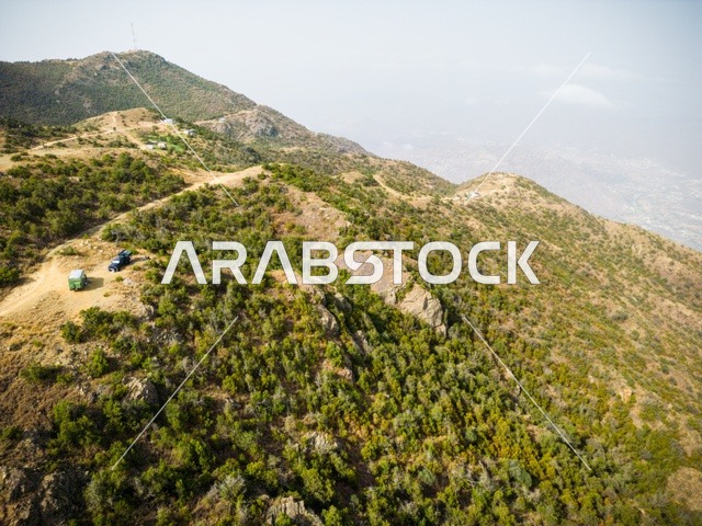 قمم ومرتفعات جبلية في محافظة النماص، الأماكن والمناطق الطبيعية في المملكة العربية السعودية، التضاريس الطبيعية والتكوينات والتشكلات الصخرية، صورة جوية للأشجار الخضراء والمزروعات على سفوح الجبال في منطقة عسير