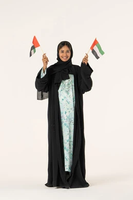 الاعتزاز بالانتماء للبلاد، الأعياد والمناسبات الوطنية، بورترية لشابة عربية خليجية عمانية ترتدي العباءة و الحجاب تمسك علم عمان بتعابير الفخر، ايماءات السعادة و السرور، الجسم بالطول الكامل، خلفية بيضاء