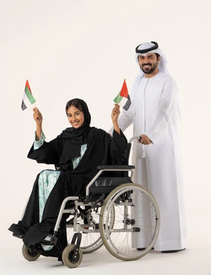 الفخر بالوطن والانتماء إليه، الأعياد والمناسبات الوطنية، بورترية لفتاه عربيه خليجيه عمانية من ذوى الاحتياجات الخاصة ترتدي العباءة و الحجاب تجلس على كرسي متحرك  برفقة زوجها تحمل العلم العماني مع تعبيرات الفخر، خلفية بيضاء