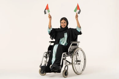 إيماءات السعادة والفرح، فخر بالانتماء إلى الوطن، العطلات الوطنية والمناسبات، بورترية لفتاه عربيه خليجيه عمانية من ذوى الاحتياجات الخاصة ترتدي العباءة و الحجاب تجلس على كرسي متحرك تحمل العلم العماني مع تعبيرات الفخر، خلفية بيضاء