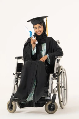 الاحتفال بإنهاء الدراسة الجامعية، أهمية الدراسة الجامعية والفرح بتحقيق النجاح، الشعور بالفرح والفخر والثقة بالنفس، مفهوم الاجتهاد والتفوق، بورتريه لطالبة عربية اماراتية خليجية من ذوي الاحتياجات الخاصة يرتدي الثوب وقبعة التخرج تجلس على كرسي متحرك تمسك بيدها شهادة التخرج , النظر الى الكاميرا بإيماءات الرضا والسرور، خلفية بيضاء