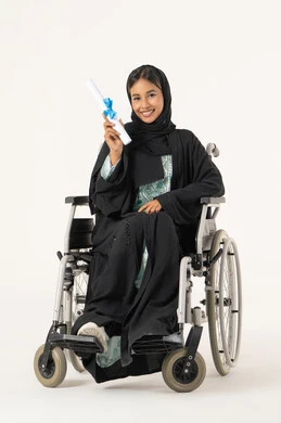 مفهوم الاجتهاد والتفوق، الشعور بالفرح والفخر والثقة بالنفس, الاحتفال بإنهاء الدراسة الجامعية، بورترية لشابة عربيه خليجيه اماراتية من ذوى الاحتياجات الخاصة ترتدي العباءة و الحجاب تجلس على كرسي متحرك تمسك  بيدها الشهادة , النظر الى الكاميرا بإيماءات الرضا والسرور, أهمية الدراسة الجامعية والفرح بتحقيق النجاح، خلفية بيضاء