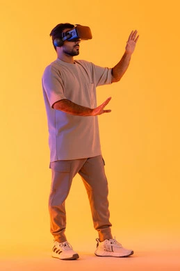 استخدام الأجهزة التقنية الحديثة والتكنولوجيا في رؤية المشاهد الخيالية، التفاعل والاندماج مع الواقع الافتراضي، بورتريه لشاب عربي خليجي إماراتي يرتدي الزي الكاجوال يضع نظارات الفي آر، رجل سعودي يقضي أوقات الفراغ بشكل ممتع، الطول الكامل للجسم، خلفية صفراء