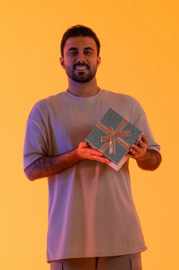 The concept of gratitude and appreciation, expressing love, respect, and admiration, giving gifts during holidays and special occasions, a Saudi man looking at the camera with gestures of joy and happiness, a portrait of a young Emirati Arab man wearing casual attire holding a gift box in his hands, with a yellow background. The concept of gratitude and appreciation, expressing love, respect, and admiration, giving gifts during holidays and special occasions, a Saudi man looking at the camera with gestures of joy and happiness, a portrait of a young Emirati Arab man wearing casual attire holding a gift box in his hands, with a yellow background.