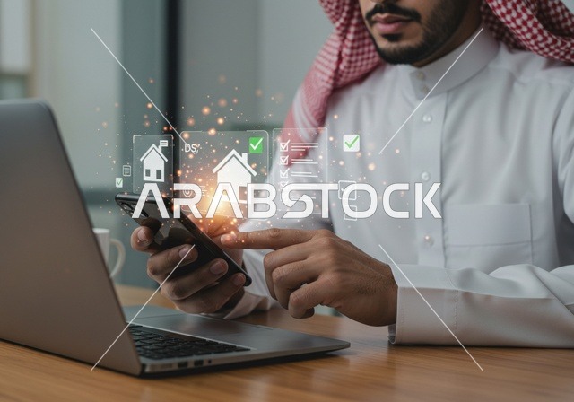 شراء عقار جديد عبر الانترنت, رجل عربي خليجي سعودي يرتدي الشماغ والثوب التقليدي يقوم باستخدام الهاتف المحمول واللابتوب، مجسم بيت جديد بتقنية الهولوجرام، امتلاك سكن حديث والاستقرار العائلي , مفهوم الاسكان والتمليك، شاشة زرقاء مضيئة