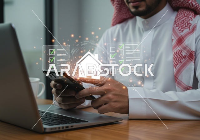 شراء عقار جديد عبر الانترنت, رجل عربي خليجي سعودي يرتدي الشماغ والثوب التقليدي يقوم باستخدام الهاتف المحمول واللابتوب، مجسم بيت جديد بتقنية الهولوجرام، امتلاك سكن حديث والاستقرار العائلي , مفهوم الاسكان والتمليك، شاشة زرقاء مضيئة