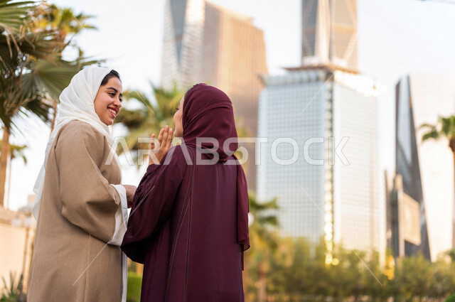 سيدتان عربيتان خليجيتان سعوديتان تتحدثان مع بعضهما البعض ، التجول في مدينة الملك عبد الله المالية كافد في مدينة الرياض في المملكة العربية السعودية ،قضاء وقت ممتع في المدينة المالية