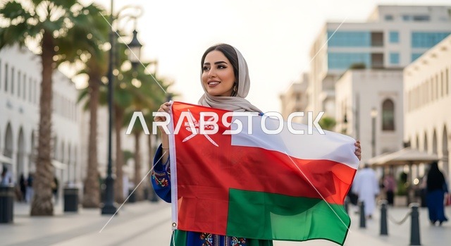 الاحتفال بالأعياد والمناسبات الوطنية, حب الوطن والانتماء إليه، إمرأة عربية خليجية عمانية ترتدي الحجاب والعباءة تمسك علم السلطنة، ذكرى اليوم الوطني العماني 18 نوفمبر، إحياء ذكرى تأسيس الدولة 1775 م، الاعتزاز والفخر بالرموز والراية