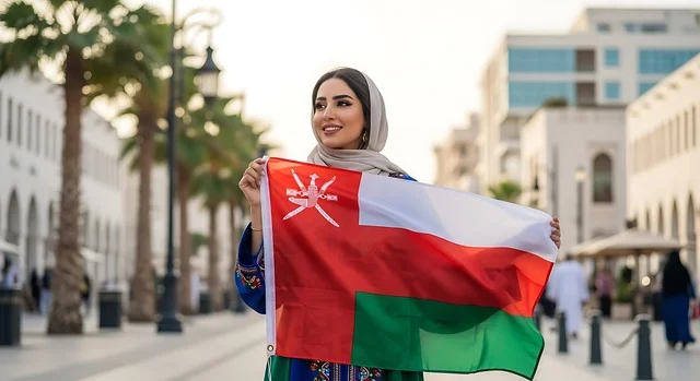 الاحتفال بالأعياد والمناسبات الوطنية, حب الوطن والانتماء إليه، إمرأة عربية خليجية عمانية ترتدي الحجاب والعباءة تمسك علم السلطنة، ذكرى اليوم الوطني العماني 18 نوفمبر، إحياء ذكرى تأسيس الدولة 1775 م، الاعتزاز والفخر بالرموز والراية
