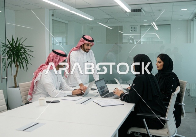 استخدام الحاسب والتقنية في مجال الاعمال، بيئة العمل المريحة في الشركات السعودية، الحوار و النقاش بين الزملاء، تبادل الخبرات والمعلومات لتحقيق الاهداف, موظفين عربيين خليجيين سعوديين يجلسون على طاولة الاجتماع داخل مقر الشركة