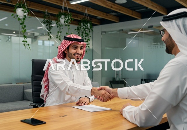 إتفاق عقد عمل جديد ، رجلان عربيان خليجيان سعوديان يتصافحان لنجاح الصفقة داخل مقر الشركة ،  مهن وأعمال تجارية ، شركة سعودية ناجحة ،  بيئة العمل المريحة في الشركات السعودية، استخدام التقنيات الحديثة في مجال الاعمال