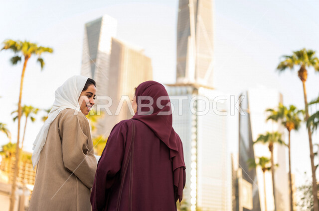 سيدتان عربيتان خليجيتان سعوديتان تتحدثان مع بعضهما البعض ، التجول في مدينة الملك عبد الله المالية كافد في مدينة الرياض في المملكة العربية السعودية ،قضاء وقت ممتع في المدينة المالية