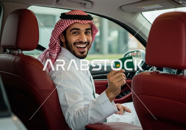 امكانية تسديد الفواتير عن بعد, ، رجل عربي خليجي سعودي يرتدي الزي التقليدي يجلس في سيارته يستخدم بطاقة الإئتمان البنكيه في التسوق الالكتروني, الشراء والدفع عبر برامج و تطبيقات الانترنت، النظر إلى الكاميرا بإيماءات السرور