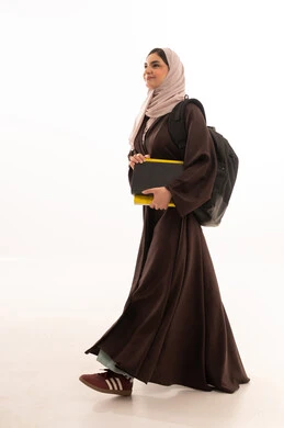 Curricula and educational materials, recording notes and important points, the importance of education in Saudi society, studying and following up on classes and lectures, a portrait of a Saudi Gulf Arab woman wearing a hijab, dressed in an abaya, carrying a backpack and university books, full-body, white background.