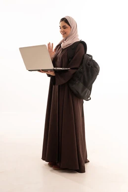 مكالمة فيديو عبر الجهاز المحمول الحاسب, استخدام الأجهزة التقنية الحديثة والمتطورة, بورتريه لامرأة عربية خليجية سعودية محجبة ترتدي العباءة وتحمل حقيبة الظهر تعمل على جهاز الحاسوب المحمول, شابة سعودية تقوم بإنجاز المهام, الجسم بالطول الكامل، خلفية بيضاء