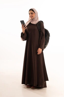 تصفح مواقع الابحاث العلمية, استخدام الأجهزة التقنية الحديثة والمتطورة, بورتريه لامرأة عربية خليجية سعودية محجبة ترتدي العباءة وتحمل حقيبة الظهر تعمل على الجهاز المحمول, شابة سعودية تقوم بإنجاز المهام, الجسم بالطول الكامل، خلفية بيضاء