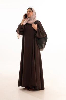 مكالمة هاتفية باستخدام الموبايل , استخدام الأجهزة التقنية الحديثة والمتطورة, بورتريه لامرأة عربية خليجية سعودية محجبة ترتدي العباءة وتحمل حقيبة الظهر تعمل على الجهاز المحمول, شابة سعودية تقوم بإنجاز المهام, الجسم بالطول الكامل، خلفية بيضاء