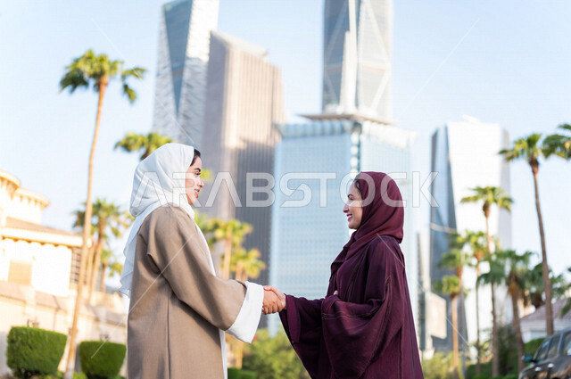 سيدتان عربيتان خليجيتان سعوديتان تتصافحان في مدينة الملك عبد الله المالية كافد في مدينة الرياض في المملكة العربية السعودية ،لقاء وتعارف ، تكوين صداقة ،جولة سياحية ، قضاء وقت ممتع في المدينة المالية