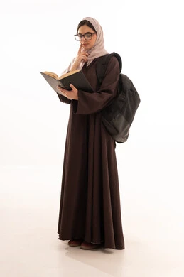 تنمية مهارة القراءة للطلاب, التعليم والدراسة في المملكة، حب الثقافة والاستطلاع، بورتريه طالبة عربية خليجية سعودية ترتدي الحجاب والعباءة تحمل مجموعة كتب تنظر إلى الكتاب بإيماءات التركيز والتأمل، قضاء وقت الفراغ بالتعلم والتثقف الذاتي, خلفية بيضاء