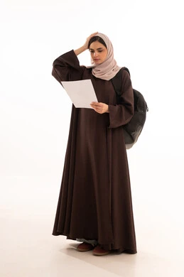 Facial and hand gestures indicating sadness and regret for receiving a low grade, lack of diligence and excellence in following lessons, a portrait of a Gulf Arab Saudi student wearing a hijab and abaya, the concept of diligence and excellence, a Saudi student who did not prepare well for the exams, white background.