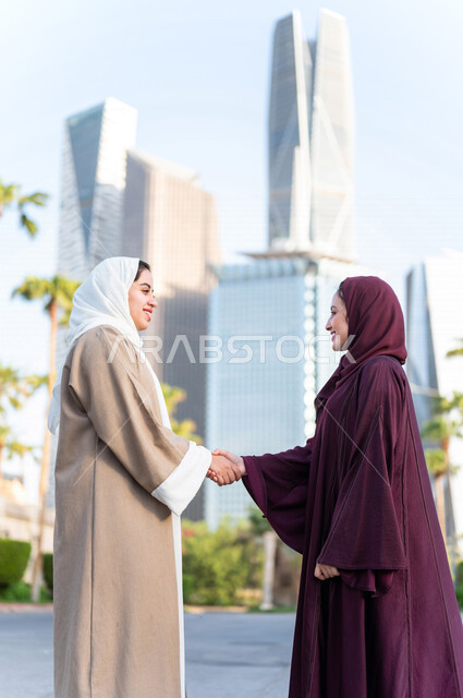 سيدتان عربيتان خليجيتان سعوديتان تتصافحان في مدينة الملك عبد الله المالية كافد في مدينة الرياض في المملكة العربية السعودية ،لقاء وتعارف ، تكوين صداقة ،جولة سياحية ، قضاء وقت ممتع في المدينة المالية