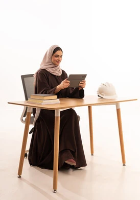 طالبة هندسة معمارية تحضر المحاضرات الجامعية عن بعد عبر التابلت، الأجهزة التقنية الحديثة بالتعلم,، متابعة المحاضرات عن طريق منصات التعلم، بورتريه مقرب لطالبه عربيه خليجيه سعودية ترتدي الحجاب والعباءة تجلس على الطاولة المكتبيه ، خلفية بيضاء