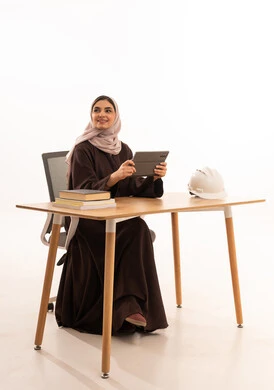 الحلم  والتمني بالمستقبل المشرق، طالبة هندسة معمارية تحضر المحاضرات الجامعية عن بعد عبر التابلت، الأجهزة التقنية الحديثة بالتعلم,، بورتريه مقرب لطالبه عربيه خليجيه سعودية ترتدي الحجاب والعباءة تجلس على الطاولة المكتبيه ، خلفية بيضاء