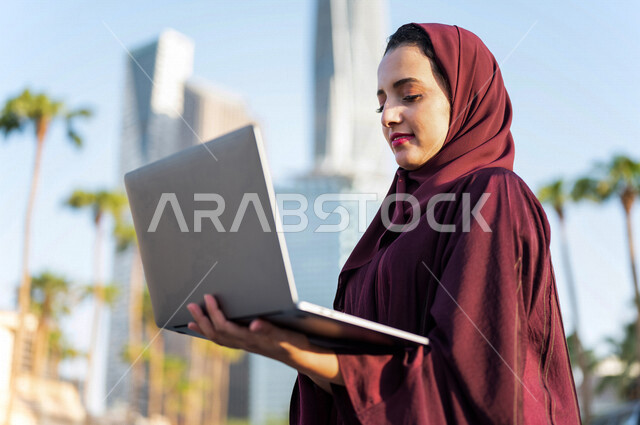 سيدة عربية خليجية سعودية تستخدم الحاسوب المحمول في مدينة الملك عبد الله المالية كافد في مدينة الرياض في المملكة العربية السعودية، مشروع عمل ، دراسة ميدانية ، العمل عن بعد