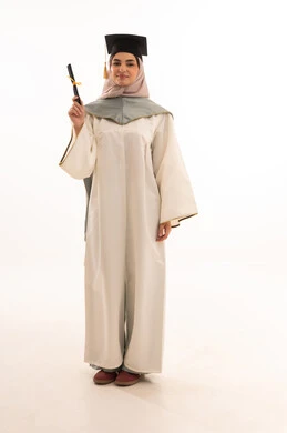 النظر الى الكاميرا بايماءات الفخر، الاحتفال بإنهاء الدراسة الجامعية، مناسبة واحتفال جامعي، إيماءات السعادة بالوصول الى الحلم، النجاح والتفوق والتخرج من الجامعة، بورتريه لخريجة عربية خليجية سعودية محجبة ترتدي زي التخرج والقبعة وتحمل شهادة التخرج ، خلفية بيضاء