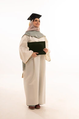 مفهوم الدراسة والنجاح والتفوق, الاحتفال بإنهاء الدراسة الجامعية، مناسبة واحتفال جامعي، إيماءات السعادة بالوصول الى الحلم، النجاح والتفوق والتخرج من الجامعة، بورتريه لخريجة عربية خليجية سعودية محجبة ترتدي زي التخرج والقبعة وتحمل شهادة التخرج ، خلفية بيضاء