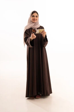 مفهوم التزين والتجمل,  التسويق لمستحضرات ومنتجات التجميل, الاهتمام والعناية بالمظهر الخارجي, استخدام المساحيق التجميلية, بورتريه لامرأة عربية خليجية سعودية محجبة ترتدي العباءة السوداء تستعمل فرشاة أحمر الخدود, شابة سعودية تضع المكياج, خلفية بيضاء