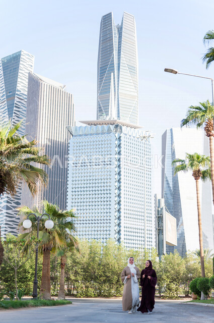 سيدتان عربيتان خليجيتان سعوديتان تتحدثان مع بعضهما البعض ، التجول في مدينة الملك عبد الله المالية كافد في مدينة الرياض في المملكة العربية السعودية ،العلاقات الاجتماعة و الصداقات ، لقاءات تعريفية نسائية ، نزهة في حدائق المملكة العربية السعودية