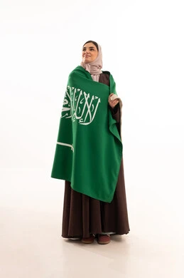 الفخر و الاعتزاز بالانتماء للوطن، استذكار اليوم الوطني السعودي 23 سبتمبر، يوم العلم 11 مارس، الاحتفال بالمناسبات الوطنية، رفع راية التوحيد والإسلام، بورتريه لامرأة عربية خليجية سعودية محجبة تحمل بيدها علم السعودية الاخضر، الجسم بالطول الكامل، خلفية بيضاء