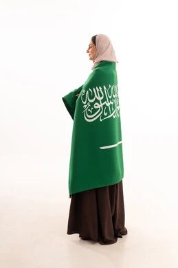 Pride and honor in belonging to the homeland, commemorating the Saudi National Day on September 23, Flag Day on March 11, celebrating national occasions, raising the banner of monotheism and Islam, a portrait of a Saudi Gulf Arab woman in a hijab holding the green Saudi flag in her hand, full-body, white background.