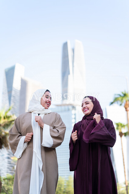 سيدتان عربيتان خليجيتان سعوديتان تتحدثان مع بعضهما البعض ، التجول في مدينة الملك عبد الله المالية كافد في مدينة الرياض في المملكة العربية السعودية ،قضاء وقت ممتع في المدينة المالية