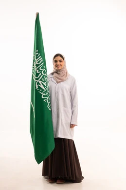 استذكار اليوم الوطني السعودي 23 سبتمبر، يوم العلم 11 مارس، إعمار البلاد بسواعد ابنائه، رفع راية التوحيد والإسلام، الاحتفال بالمناسبات الوطنية، بورتريه لطبيبة عربية خليجية سعودية محجبة ترتدي المعطف الطبي تحمل بيدها علم السعودية ، الطول الكامل للجسم، خلفية بيضاء