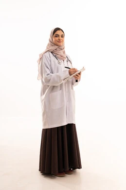 Providing therapeutic services in medical centers and hospitals, the concept of medicine and healthcare, working in the health sector, a portrait of a Gulf Arab Saudi female doctor wearing a colorful abaya with a medical coat, recording and documenting patient information, full-body image, white background.
