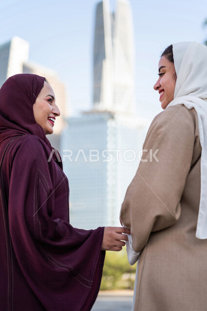 سيدتان عربيتان خليجيتان سعوديتان تتحدثان مع بعضهما البعض ، التجول في مدينة الملك عبد الله المالية كافد في مدينة الرياض في المملكة العربية السعودية ،قضاء وقت ممتع في المدينة المالية