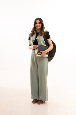 Preparation for the new academic year, universities and academic colleges, a portrait of a young Arab Gulf Saudi university student wearing casual attire, carrying a backpack, holding books in her hand, following daily lessons, full-body image, white background.