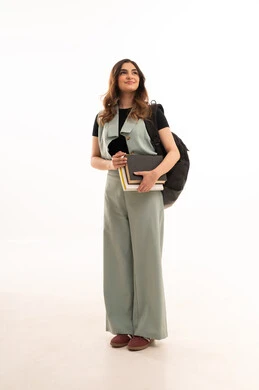 لجامعات والكليات الأكاديمية،الاستعداد للعام الجامعي الجديد،ا  بورتريه لشابة  جامعية عربية خليجية سعودية ترتدي الزي الكاجوال  تحمل حقيبة الظهر تمسك بيدها الكتب تقوم بمتابعة الدروس اليومية، صورة لكامل الجسم، خلفية بيضاء