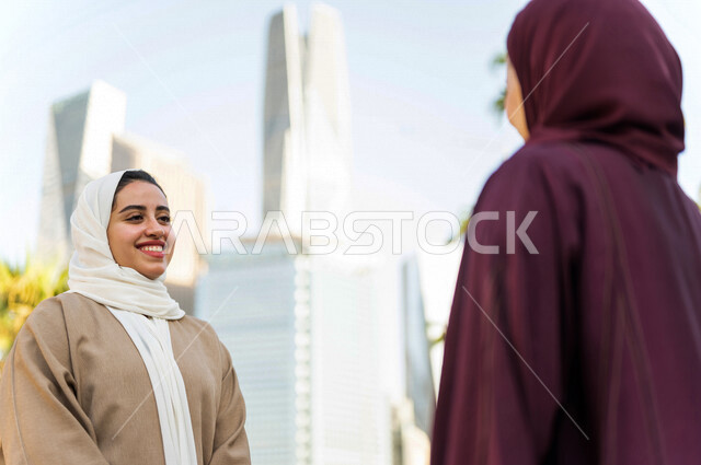 Two Saudi Arabian Gulf ladies talking to each other, touring in King Abdullah Financial City, Kafed in Riyadh, Kingdom of Saudi Arabia, having a great time in the financial city