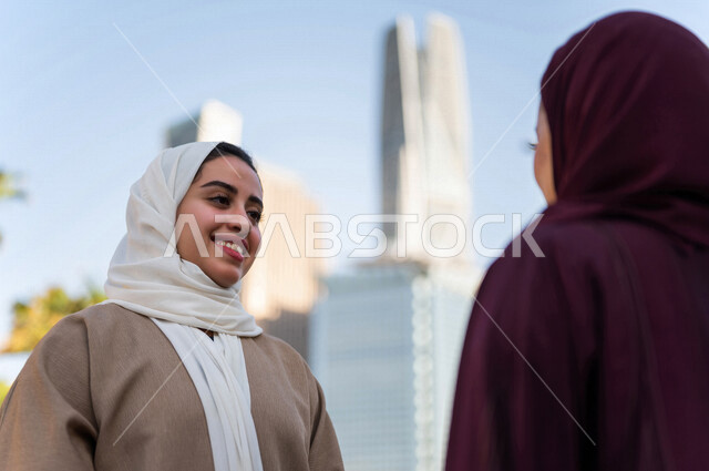 سيدتان عربيتان خليجيتان سعوديتان تتحدثان مع بعضهما البعض ، التجول في مدينة الملك عبد الله المالية كافد في مدينة الرياض في المملكة العربية السعودية ،قضاء وقت ممتع في المدينة المالية