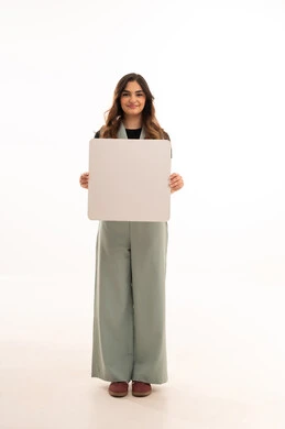 موك اب ابيض فارغ، عرض و اعلان تسويقي, بورتريه لإمرأة عربية خليجية سعودية  مبتسمه ترتدي الزي الكاجوال تمسك بيديها لوحة بيضاء مستطيلة فارغة ، الجسم بالطول الكامل, خلفية بيضاء