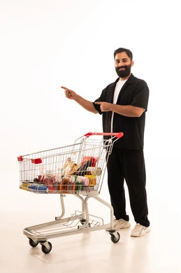 الاستمتاع بالتسوق في المولات والمراكز التجارية، شراء المستلزمات والحاجيات الضرورية،الاستفادة من الخصومات والتنزيلات على المنتجات، بورتريه لرجل عربي خليجي عماني يرتدي الزي الكاجوال يقف و عربة المشتريات أمامه ، الجسم بالطول الكامل، خلفية بيضاء