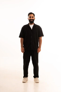 بورتريه لشاب عربي خليجي عماني يرتدي الزي الكاجوال ينظر بتعابير السعادة ، مفهوم الاناقة و الاهتمام بالمظهر الخارجي, صورة الجسم بالطول الكامل, خلفية بيضاء