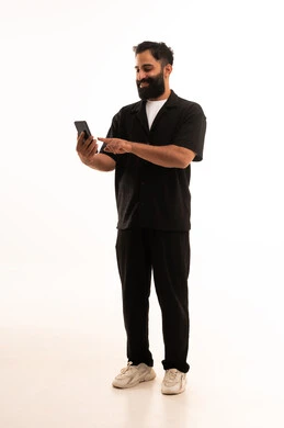 The use of modern and advanced technologies, gestures of happiness upon hearing good news, a portrait of an Arab Gulf Omani man wearing casual attire holding a mobile phone in his hand, full-body, white background.
